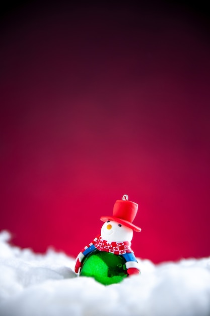 Free photo front view mini snowman on dark red background