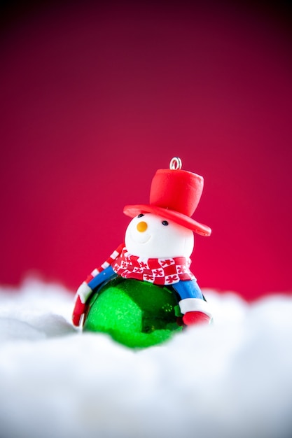 Мини-снеговик вид спереди на красном фоне