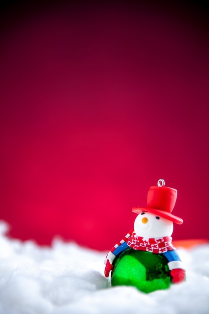 Мини-снеговик вид спереди на красном фоне