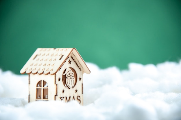 Mini casa in legno vista frontale su sfondo verde Foto Gratuite
