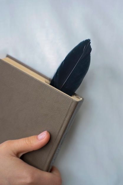 Front view model holding book with feather