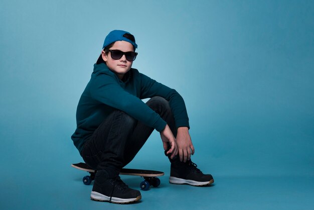 스케이트 보드에 앉아 현대 소년의 전면 모습