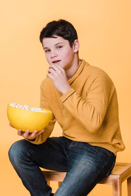Foto gratuita vista frontale del ragazzo moderno con popcorn