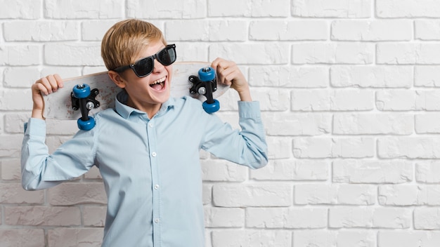 Front view of modern boy with skateboard and copy space