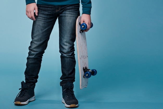 Front view of modern boy with skateboard