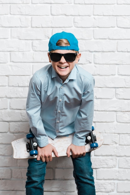 Foto gratuita vista frontale del ragazzo moderno con skateboard