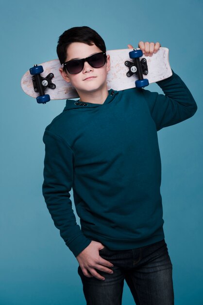Вид спереди современного мальчика с солнцезащитные очки позирует