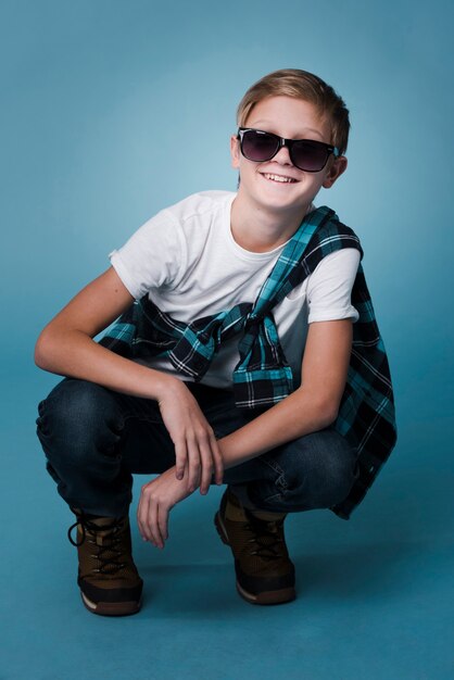 Front view of modern boy with sunglasses posing