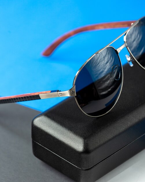 A front view modern dark sunglasses on the dark-blue