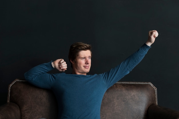 Front view modern man relaxing on the couch indoors