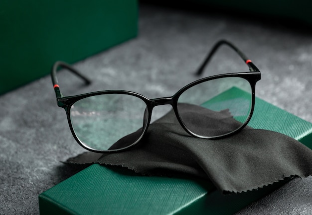 Gli occhiali da sole moderni di vista frontale moderni sulla scrivania grigia hanno isolato l'eleganza degli occhiali di visione