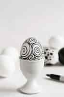 Free photo front view of monochrome egg for easter in egg cup with copy space