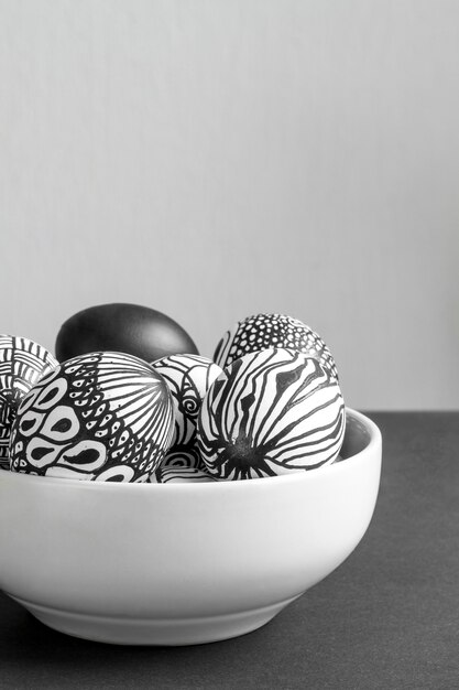 Front view of monochrome eggs for easter in bowl with copy space