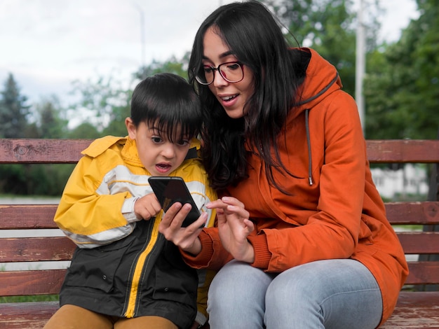 Vista frontale madre e figlio utilizzando il telefono cellulare