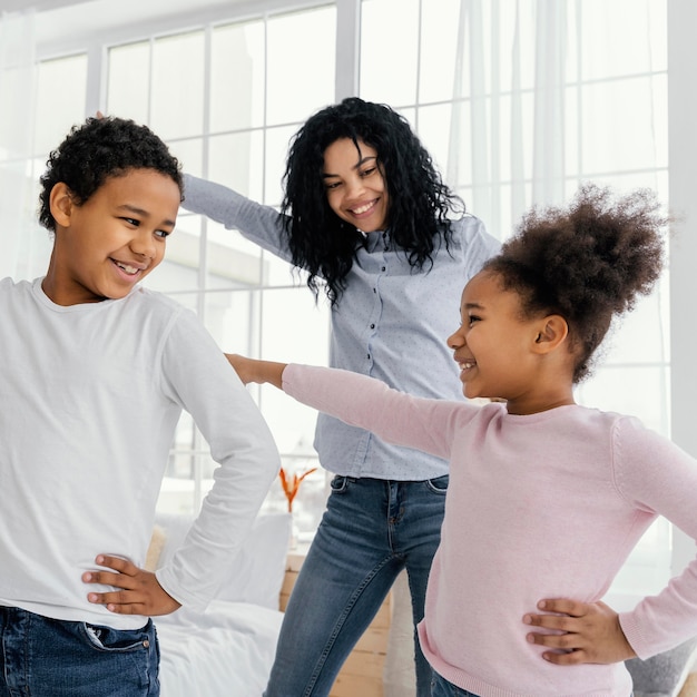 Free photo front view of mother dancing at home with her children