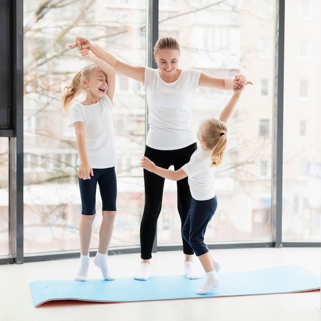 Front view of mother and daughters working out at home