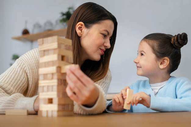 Free photo front view mother and girl playing game