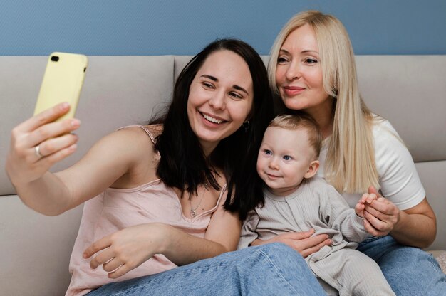 Front view of mother and grandmother taking selfie with child