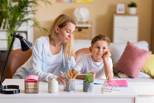 Front view mother and son doing homework indoors