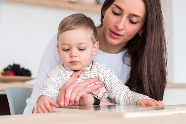 Vista frontale della madre con bambino in cucina