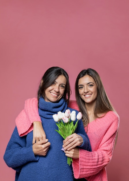 Вид спереди мама с цветами от дочери
