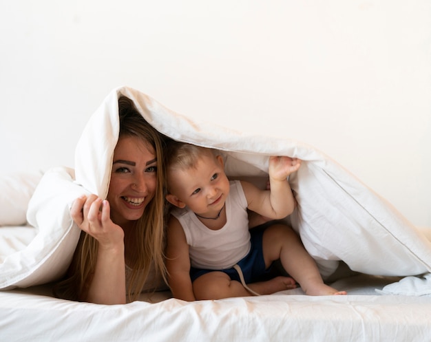 Front view mother with son under a blanket