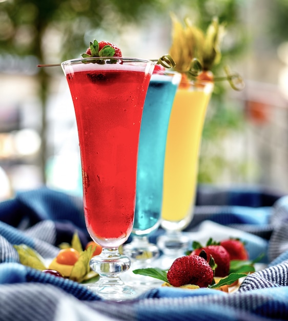 Vista frontale cocktail multicolori con decorazioni di frutta