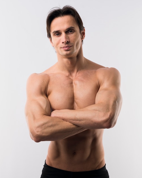 Front view of muscled man posing with arms crossed