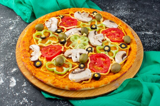 Front view mushroom pizza with red tomatoes olives mushrooms all sliced inside on dark