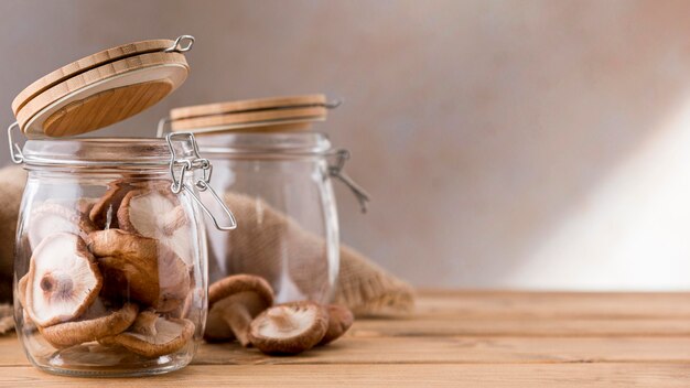 Front view of mushrooms in clear jars with copy space