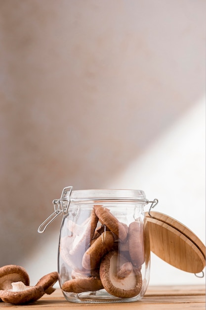 Front view of mushrooms in glass jar with copy space