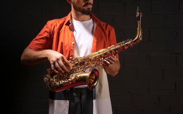 Free photo front view of musician playing saxophone