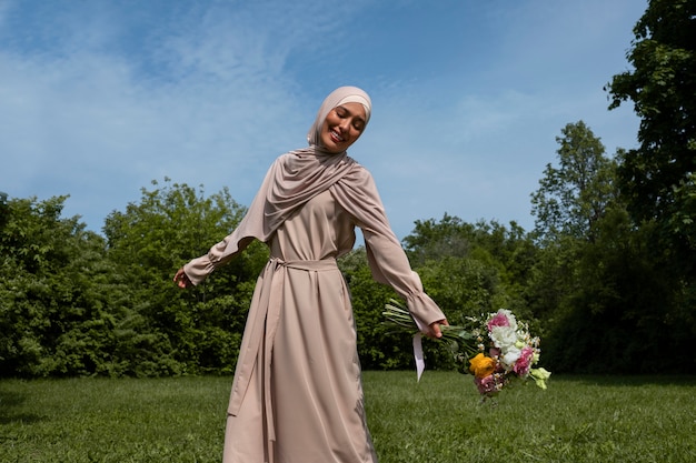 Бесплатное фото Вид спереди мусульманка позирует на открытом воздухе