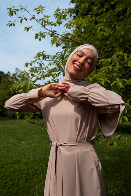 Foto gratuita donna musulmana di vista frontale che posa all'aperto