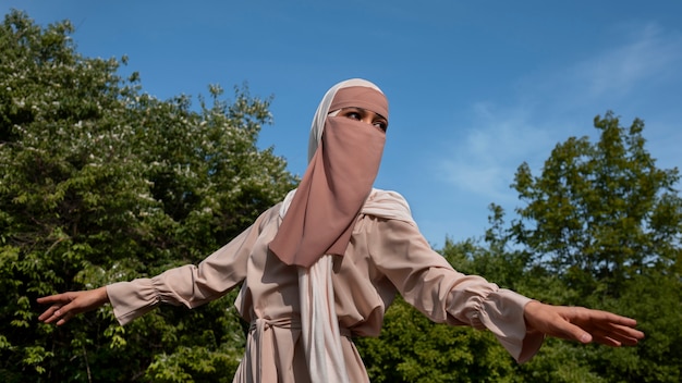 正面図のイスラム教徒の女性が屋外でポーズ