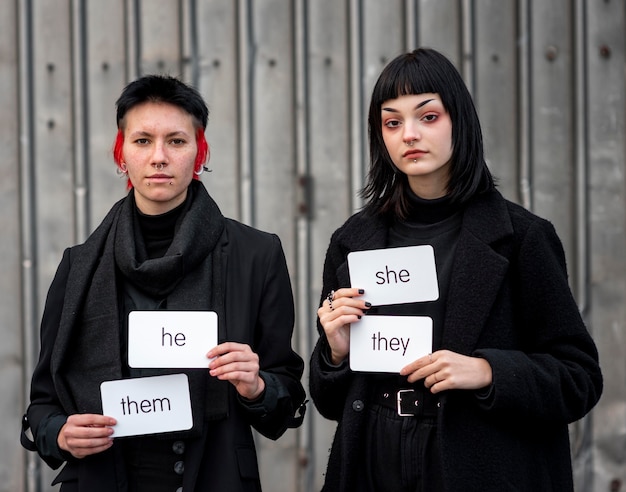 Front view non binary people holding pronouns cards