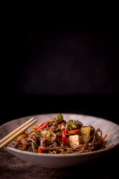 Front view of noodles in bowl with vegetables