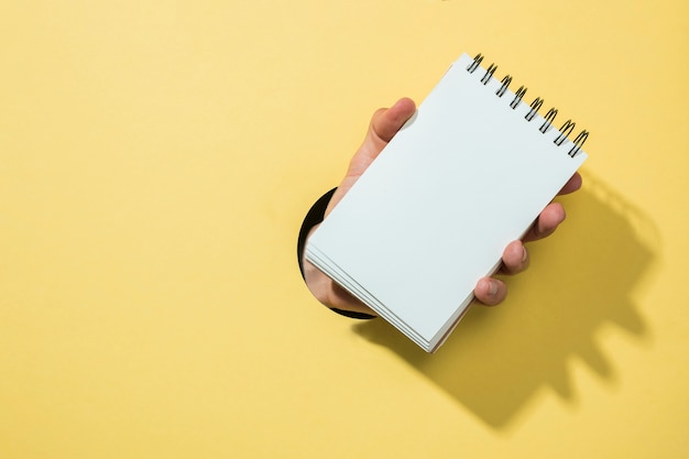 Free photo front view notebook with yellow background