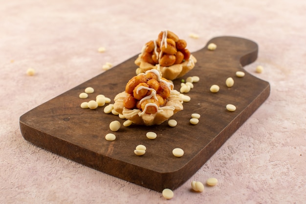 Free photo a front view nut cakes delicious and sticky on the wooden desk cake