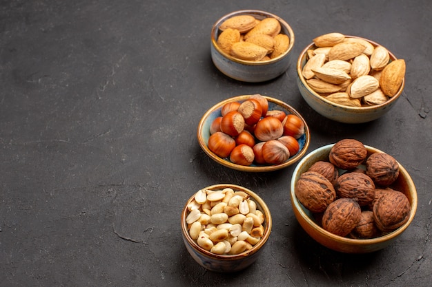 暗い表面の鉢の中のナッツ組成物の新鮮なナッツの正面図