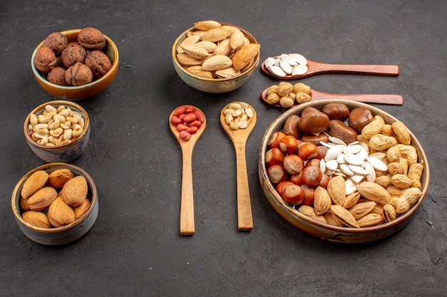 Free photo front view of nut composition with different nuts on dark surface