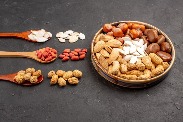 Front view of nut composition with different nuts on dark surface