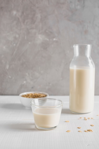 Front view oatmeal with milk bottle and glass on table