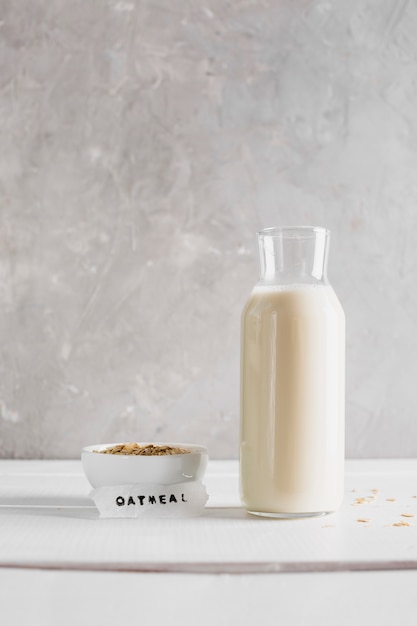 Front view oatmeal with milk bottle on table