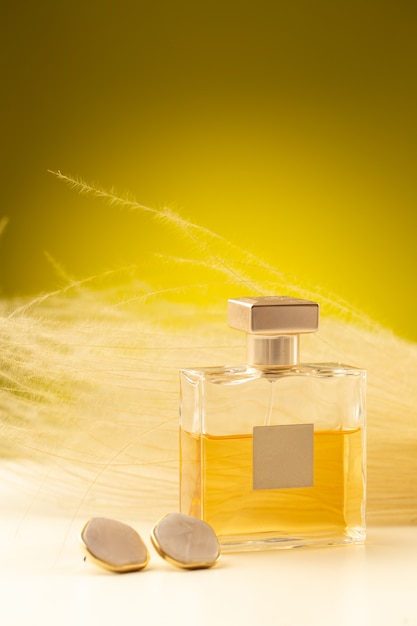 無料写真 黄色の表面にフラスコ内の美しい光の香水の正面図