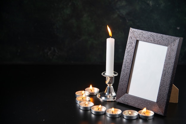Бесплатное фото Вид спереди горящих свечей как память о упавших на черную поверхность