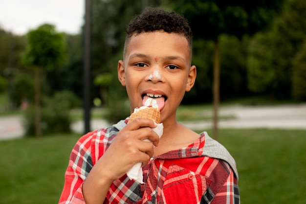 無料写真 アイスクリームを食べるかわいい男の子の正面図
