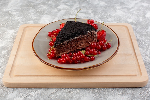 무료 사진 나무 책상에 초코 크림과 신선한 빨간 크랜베리 썰어 맛있는 초콜릿 케이크의 전면보기
