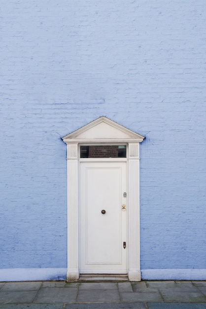 Бесплатное фото Вид спереди на входную дверь с синей стеной