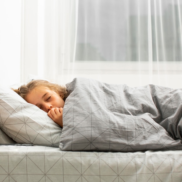 無料写真 ベッドで寝ている女の子の正面図